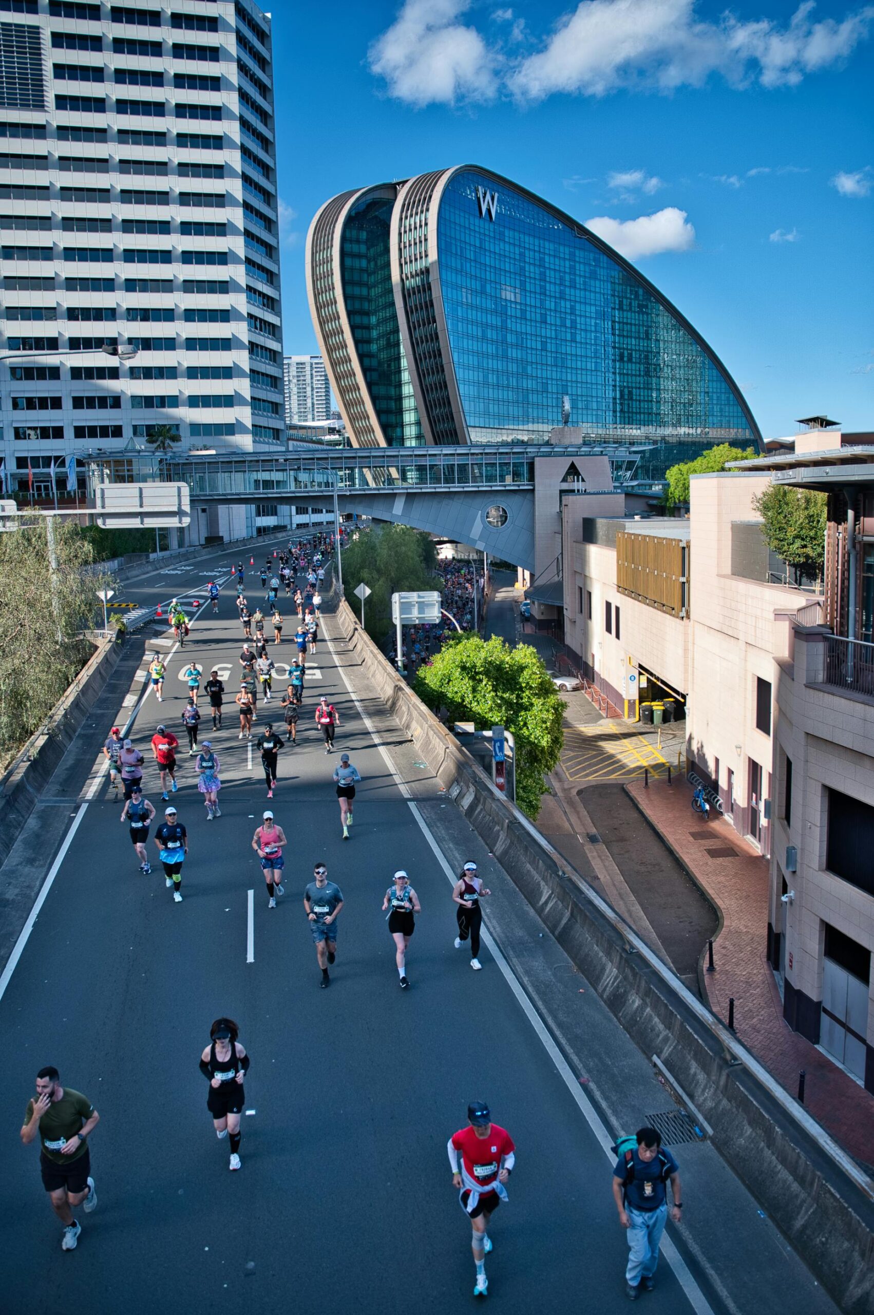 A group of runners participating in a marathon in Sydney, Australia. The event takes place in a vibrant urban setting.